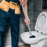 A plumber working on an emergency toilet repair.